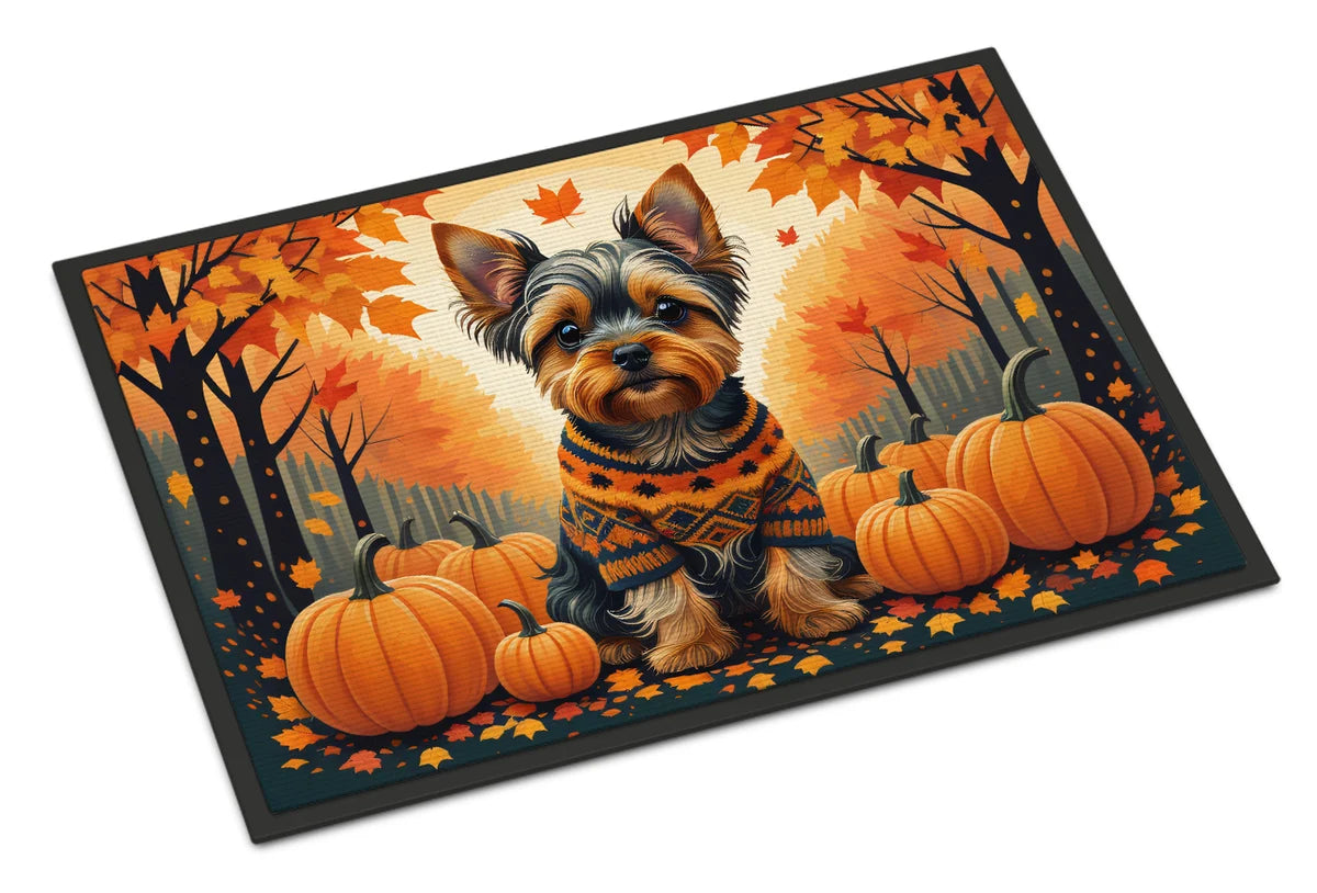 Dog in a sweater with pumpkins and autumn leaves on a decorative mat