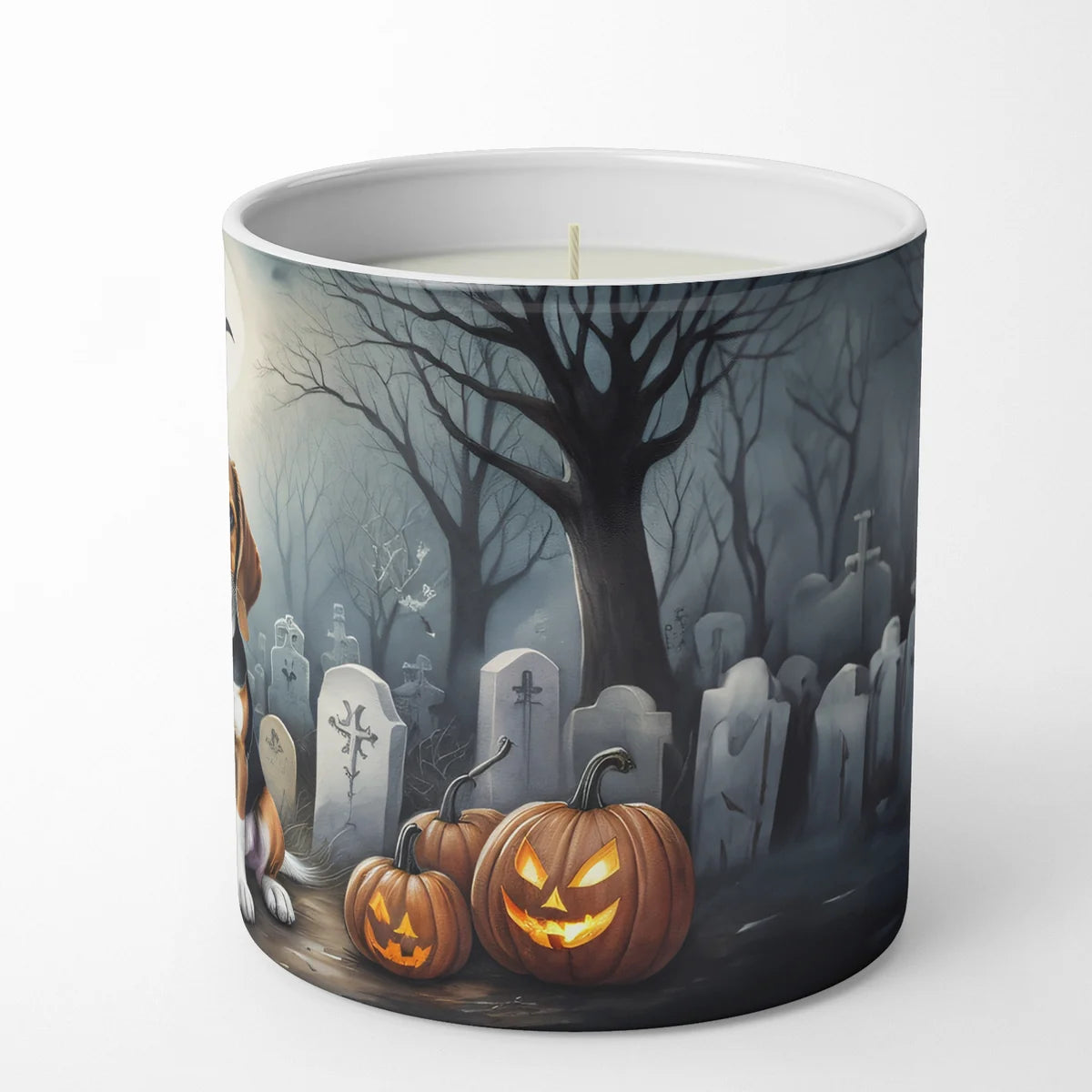 Candle with a Halloween-themed design of pumpkins and a graveyard on a white background