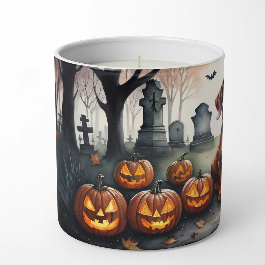 Candle with Halloween-themed design featuring pumpkins and a graveyard on a white background
