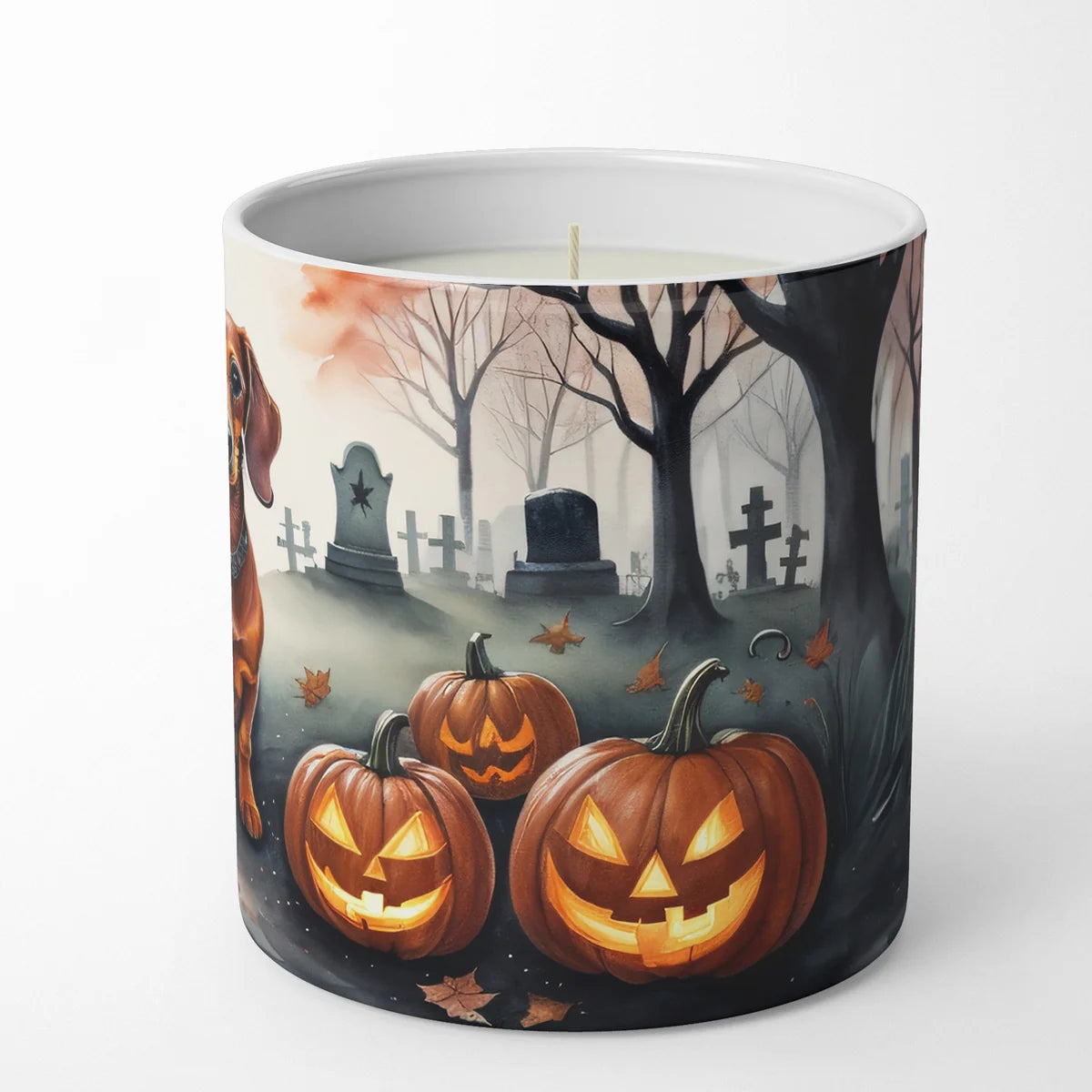 Candle with Halloween design featuring pumpkins and a graveyard on a white background
