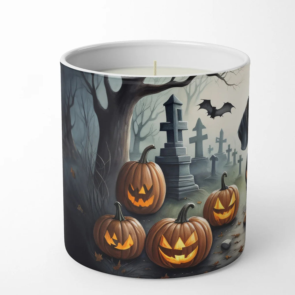 Candle with Halloween design featuring pumpkins, bats, and a tombstone.