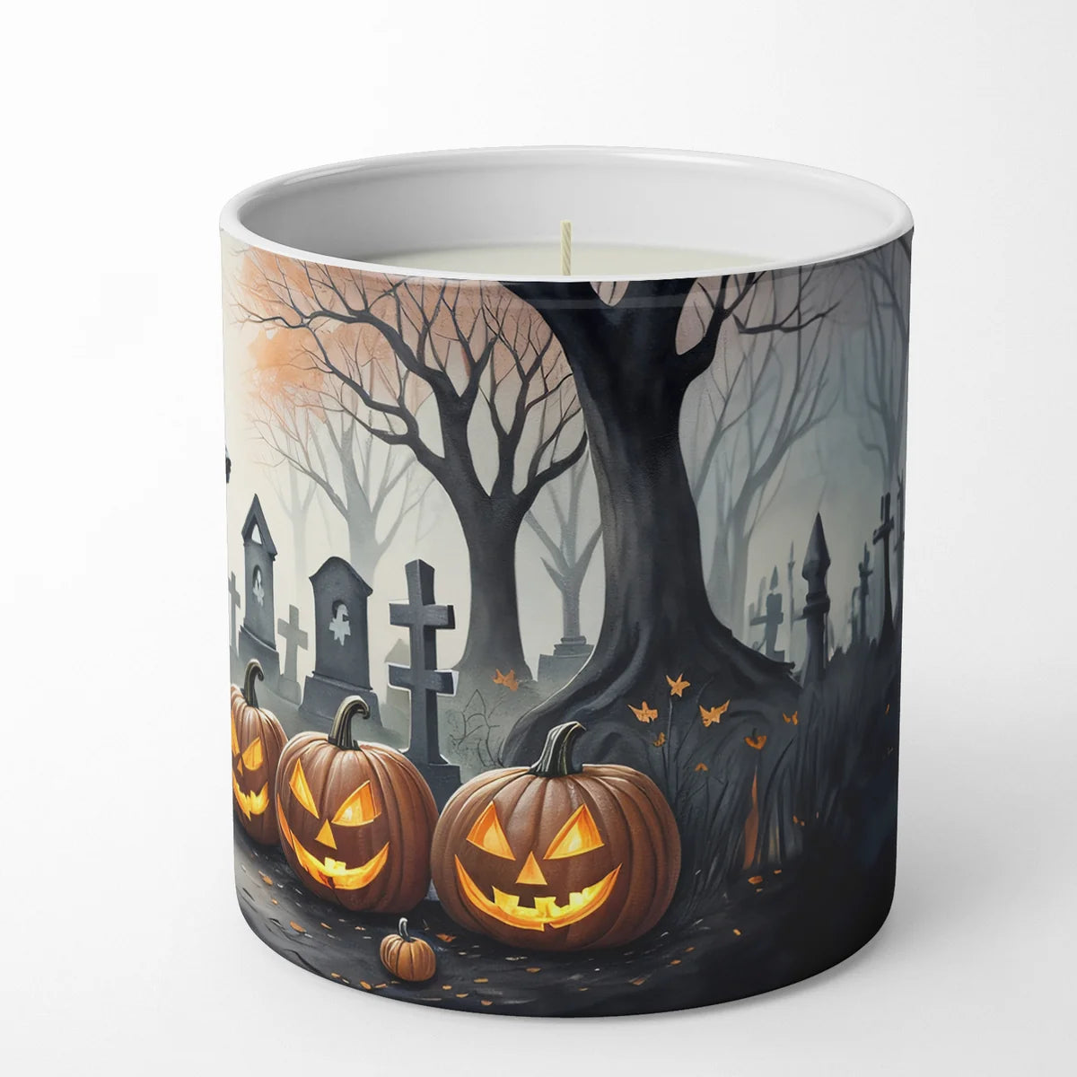 Candle with Halloween design featuring pumpkins and a graveyard on a white background