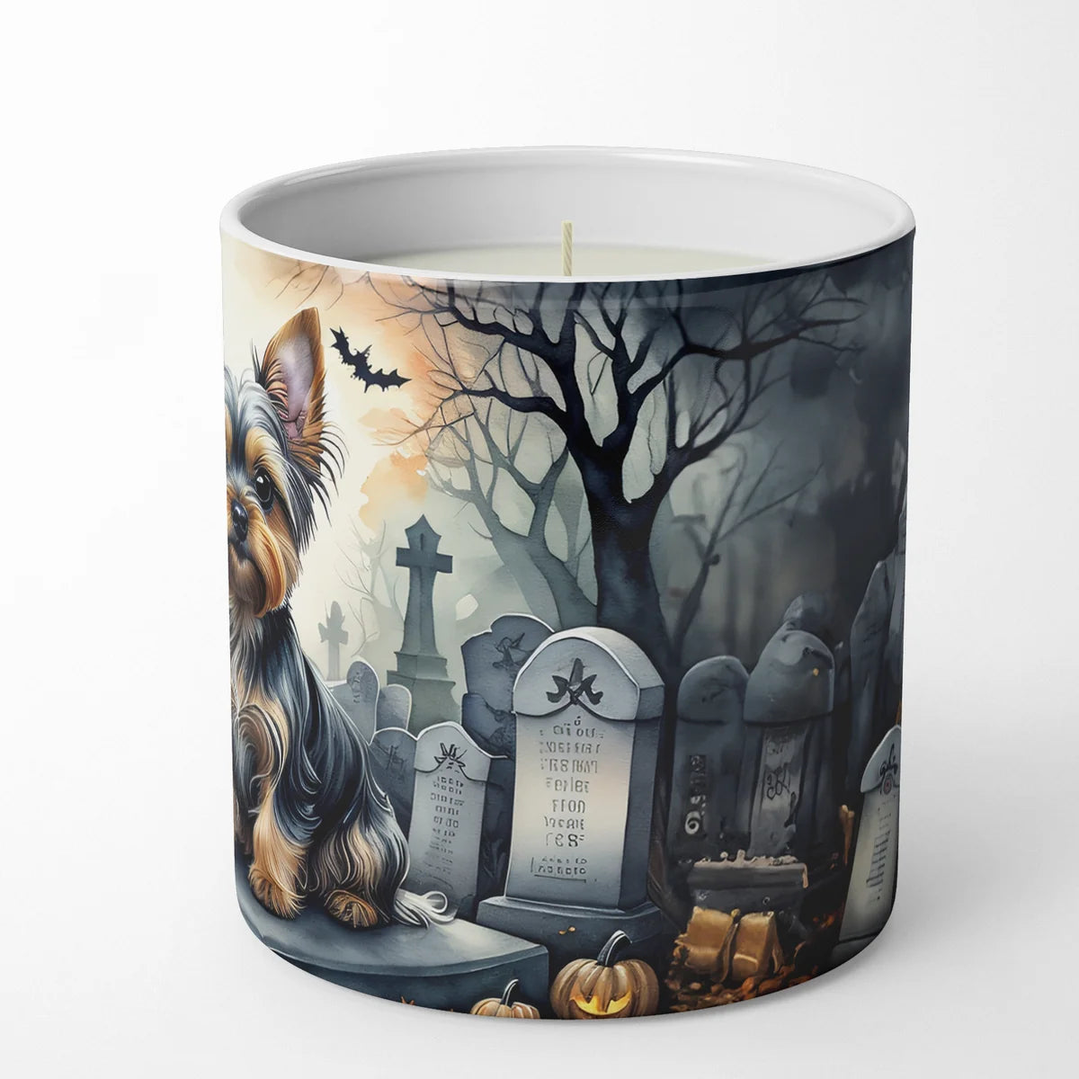 Candle with a Halloween-themed design featuring a dog, tombstones, and pumpkins on a white background.