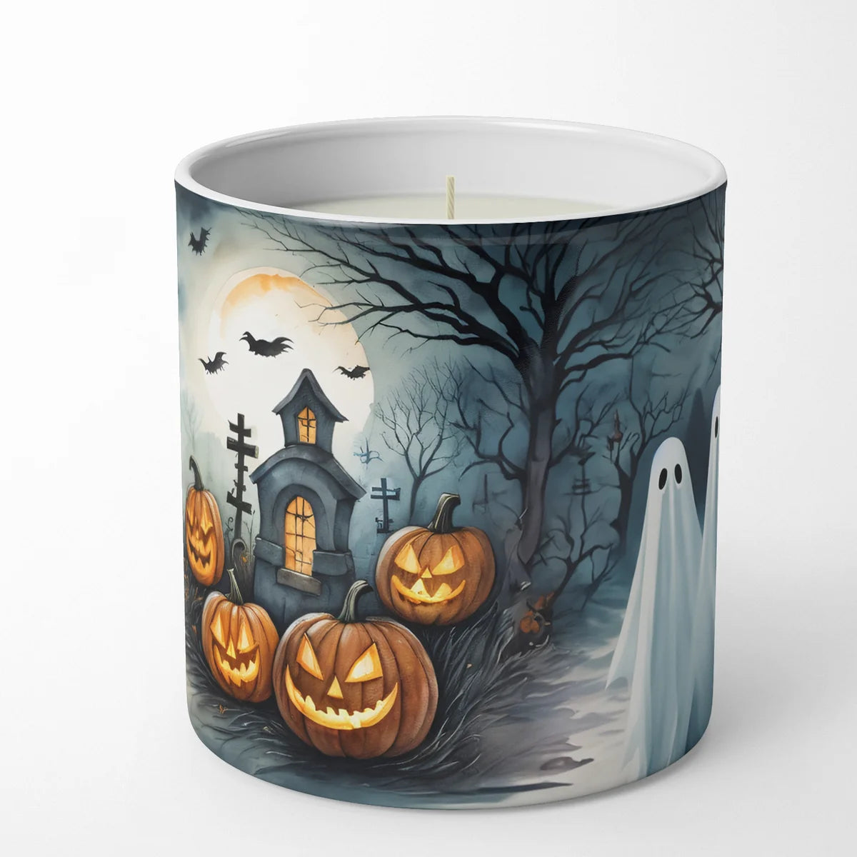 A white ceramic candle jar featuring a detailed Halloween-themed illustration on the outside. The artwork depicts carved pumpkins, a haunted house, bare trees, bats, a ghost, and a full moon against a dark blue-gray sky.
