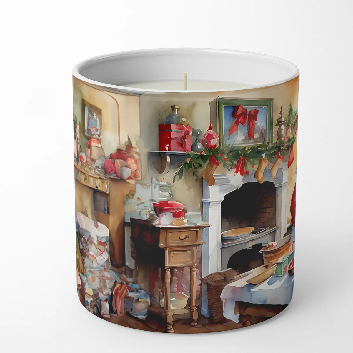 A cylindrical candle with a white wax fill and a single wick, featuring a printed Christmas-themed interior scene on the outside. The artwork shows a fireplace mantel with stockings, green garland, red bows, and holiday decorations in warm beige, brown, red, and green tones.