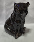 A glossy black ceramic bank of a black bear, shown from a high-angle perspective on a white fabric background.