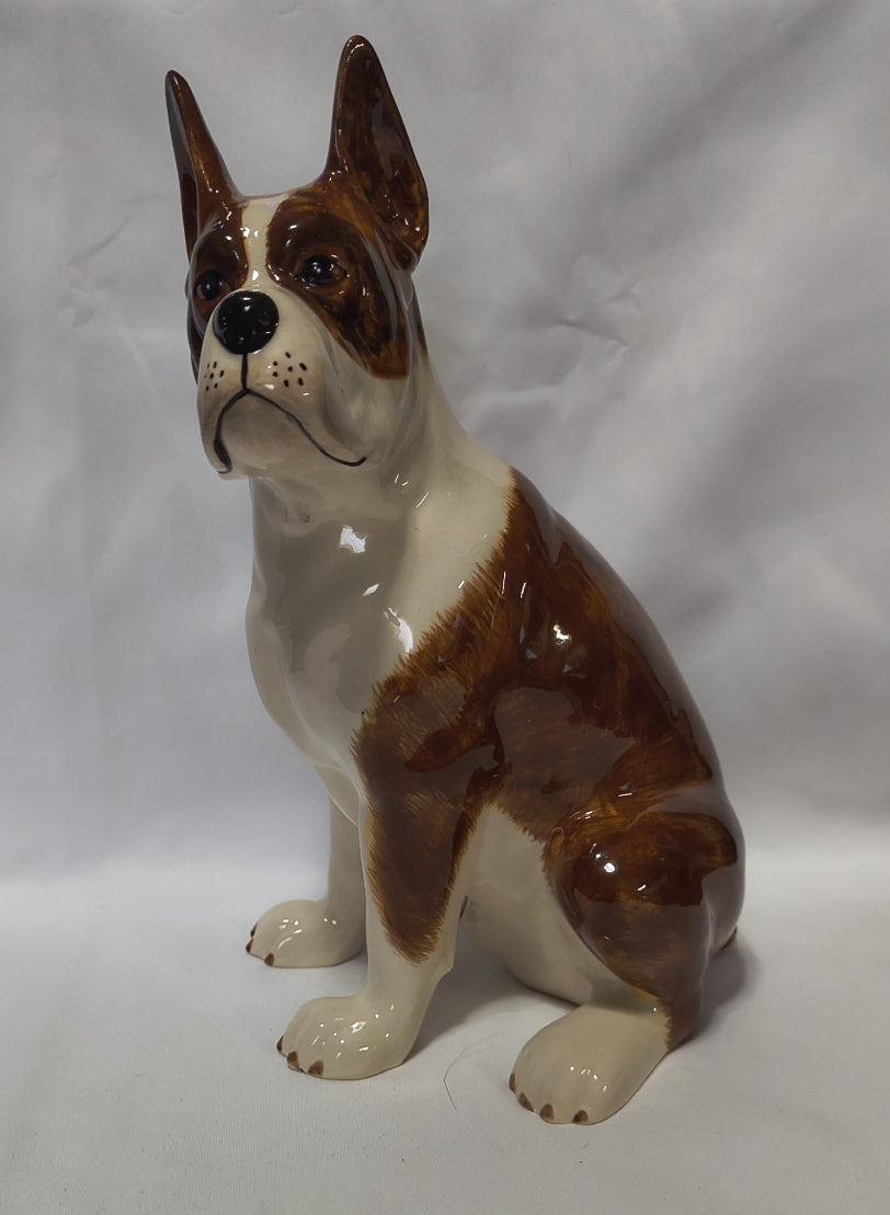 A glossy hand-painted ceramic Boxer Bank photographed against a wrinkled white fabric backdrop.