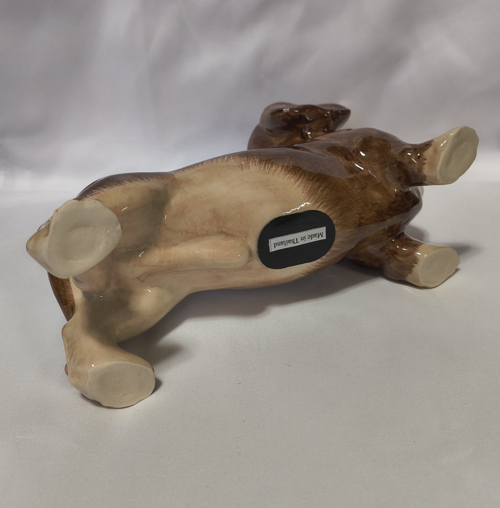 A glossy ceramic dachshund bank shown from underneath on a white studio background.