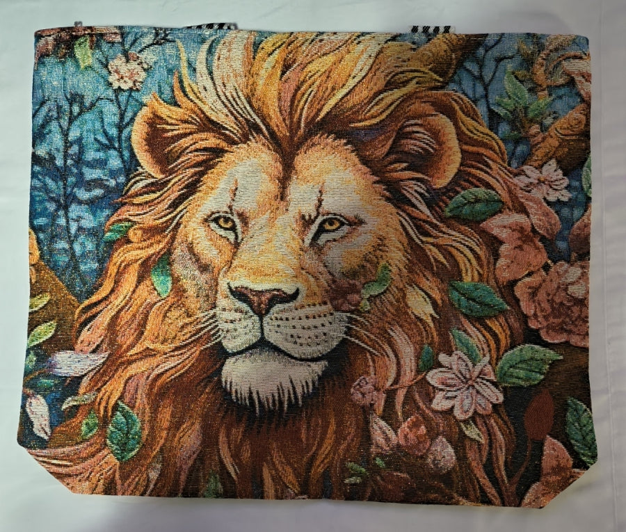A square canvas bag featuring a detailed tapestry-style print of a lion's face surrounded by flowers and leaves on a blue-toned background.