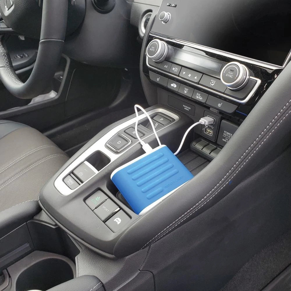 Blue power bank plugged into a car's USB port.