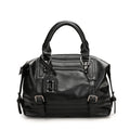 Black handbag with multiple zippers on a white background