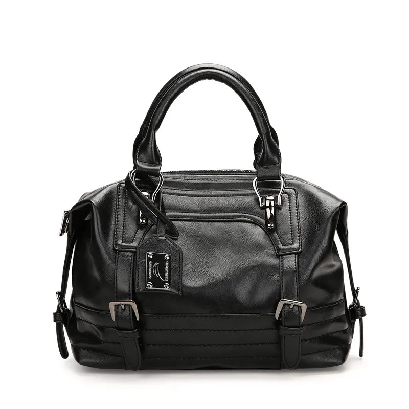 Black handbag with multiple zippers on a white background