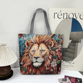 Tote bag with a lion design on a surface with a magazine and lamp in the background
