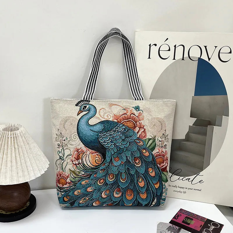 Tote bag with peacock design on a surface next to a magazine