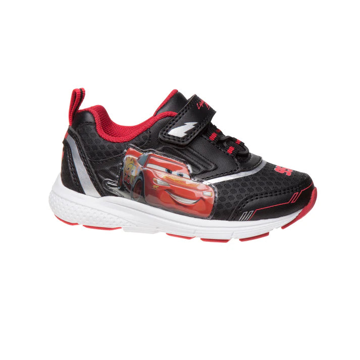 A children's black and red sneaker featuring a graphic of Lightning McQueen from Disney's Cars on the side, with a hook-and-loop strap closure and a white midsole.