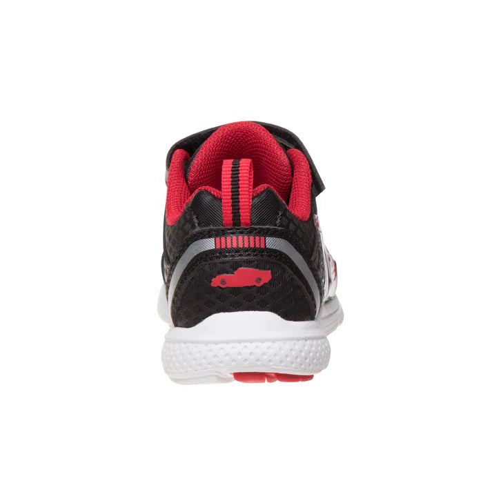 A single children's sneaker shown from the back, featuring a black textured upper with red accents, a red pull tab, a red car logo on the heel, and a white midsole.